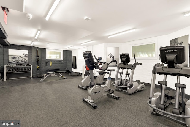 exercise room featuring brick wall