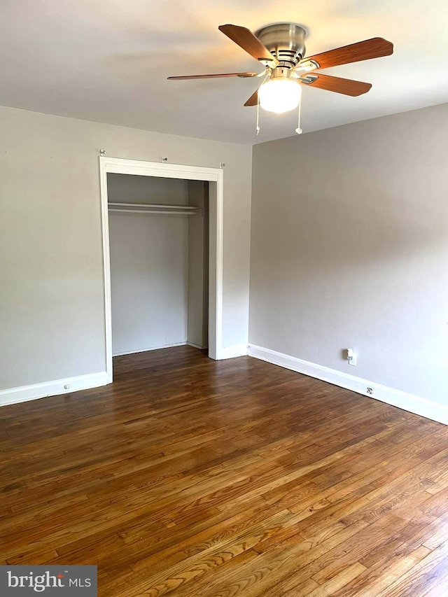 unfurnished bedroom with ceiling fan, a closet, and hardwood / wood-style flooring