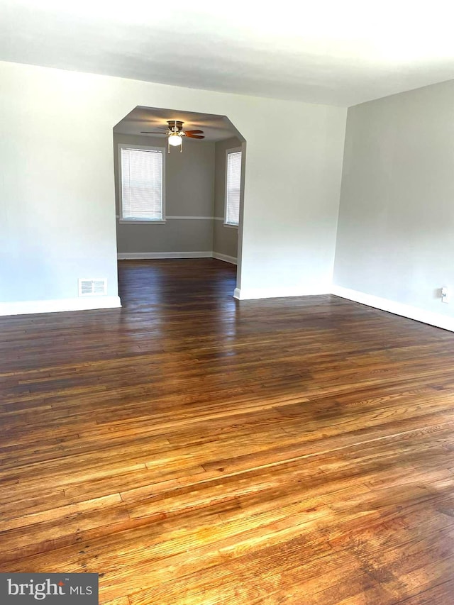 empty room with ceiling fan and dark wood-type flooring