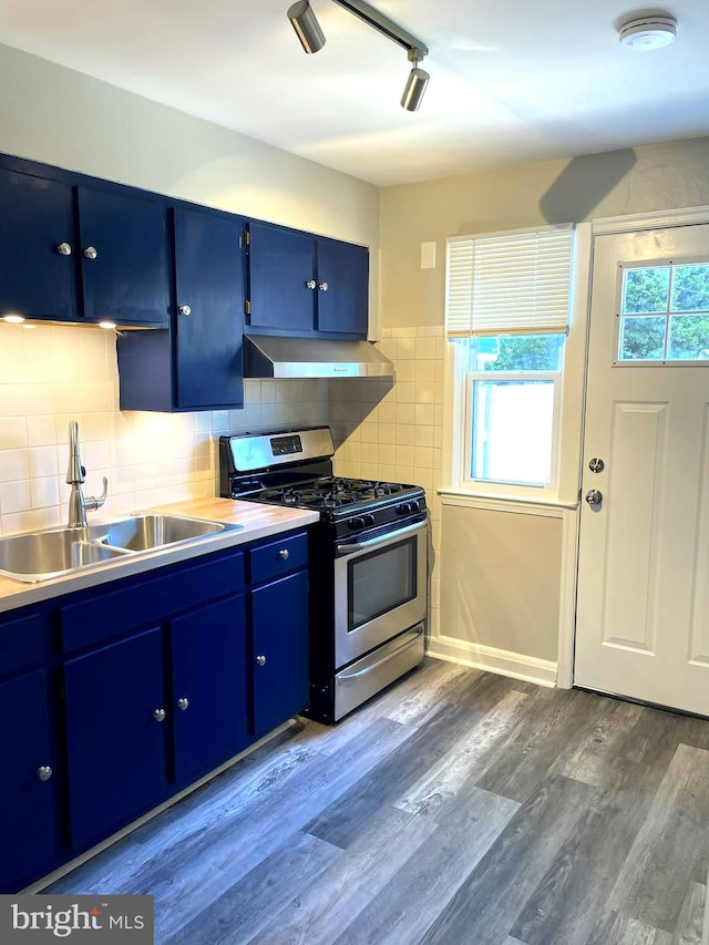 kitchen with sink, stainless steel range with gas stovetop, decorative backsplash, hardwood / wood-style floors, and blue cabinets