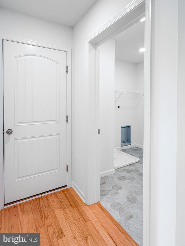 hallway featuring baseboards and wood finished floors