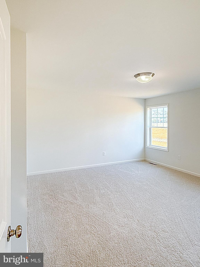 unfurnished room featuring baseboards, carpet floors, and visible vents