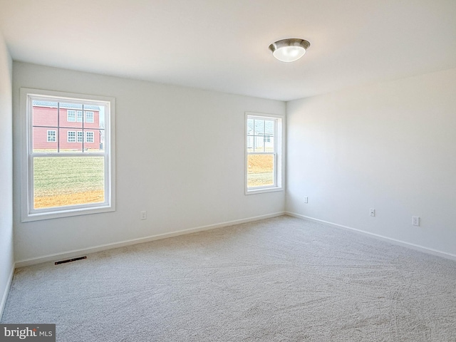 carpeted empty room with visible vents and baseboards