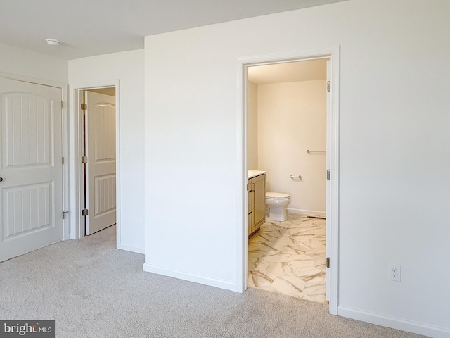 unfurnished bedroom featuring light colored carpet, baseboards, and connected bathroom