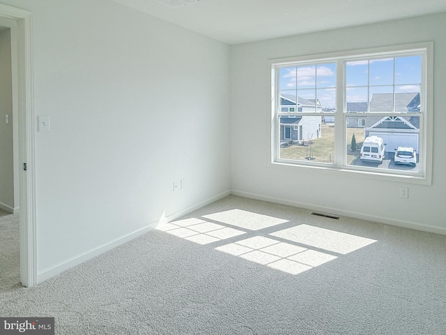 unfurnished room with visible vents, baseboards, and carpet