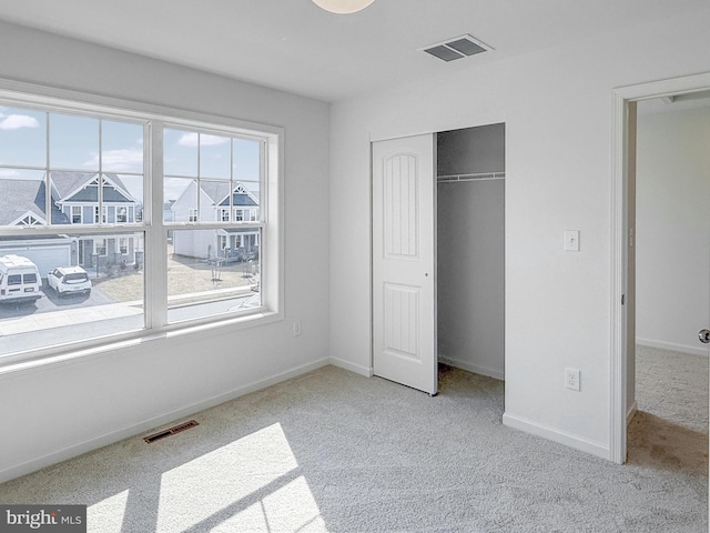 unfurnished bedroom featuring visible vents, baseboards, a closet, and carpet flooring