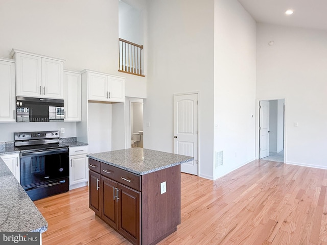 kitchen with white cabinetry, black appliances, light wood-style flooring, and visible vents