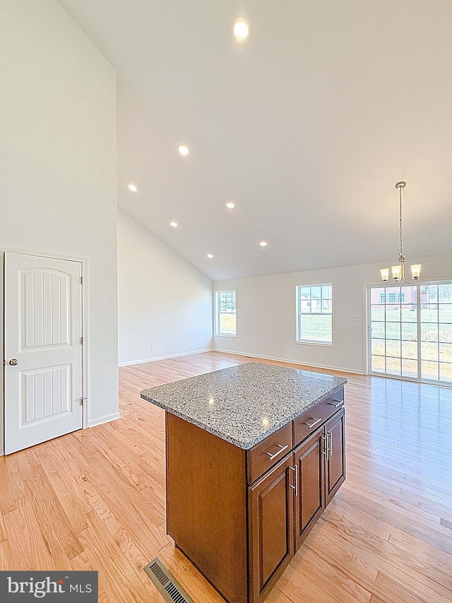 kitchen with visible vents, open floor plan, and light wood finished floors