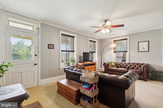 carpeted living room with a healthy amount of sunlight, ceiling fan, and ornamental molding