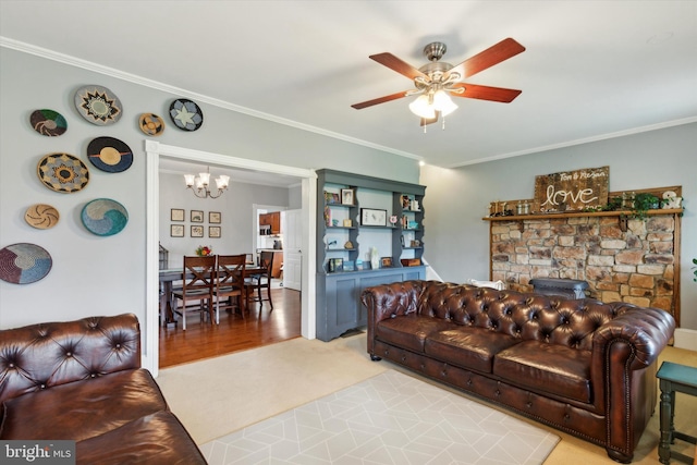 carpeted living room with ornamental molding, ceiling fan with notable chandelier, and a fireplace