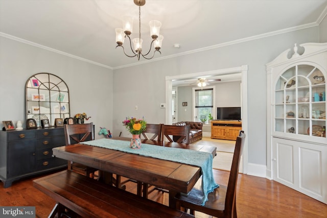 dining room featuring ceiling fan with notable chandelier, wood-type flooring, and ornamental molding