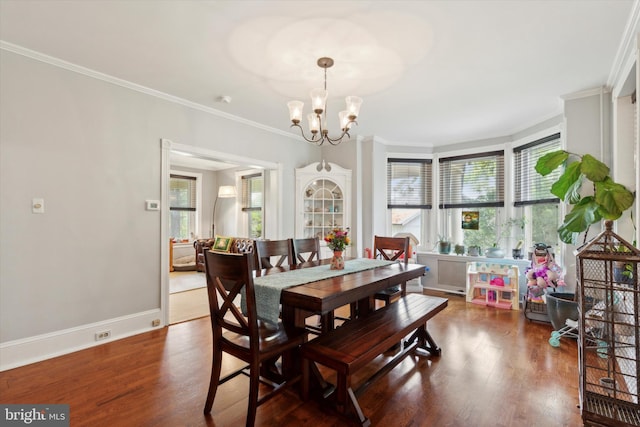 dining area with ornamental molding, a notable chandelier, and hardwood / wood-style flooring