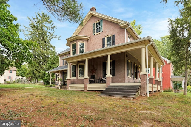 view of front of home featuring covered porch and a front yard