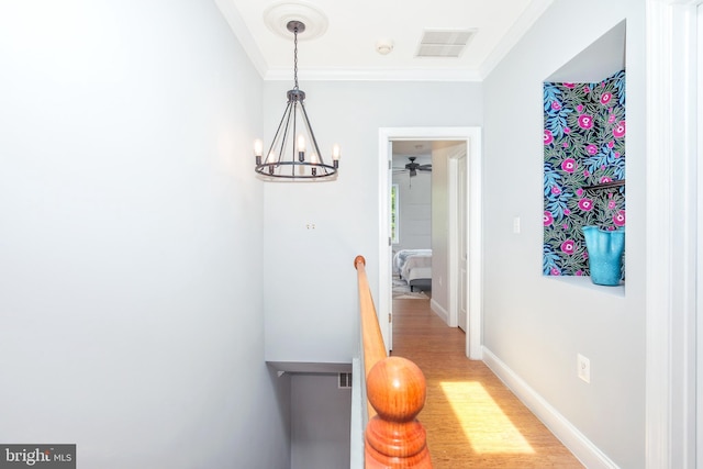 hall with light wood-type flooring and crown molding