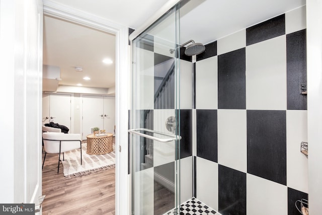 bathroom with hardwood / wood-style flooring and a shower with door