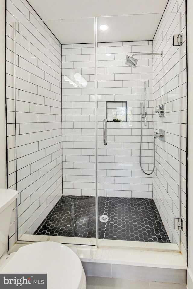 bathroom featuring walk in shower and toilet