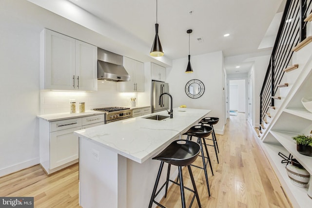 kitchen featuring an island with sink, white cabinets, stainless steel appliances, and sink