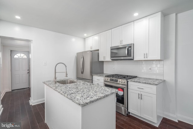 kitchen featuring a center island with sink, dark wood-type flooring, appliances with stainless steel finishes, and white cabinets