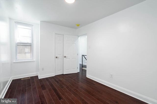 unfurnished bedroom featuring dark hardwood / wood-style flooring