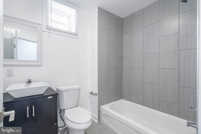 full bathroom with tiled shower / bath, vanity, and toilet