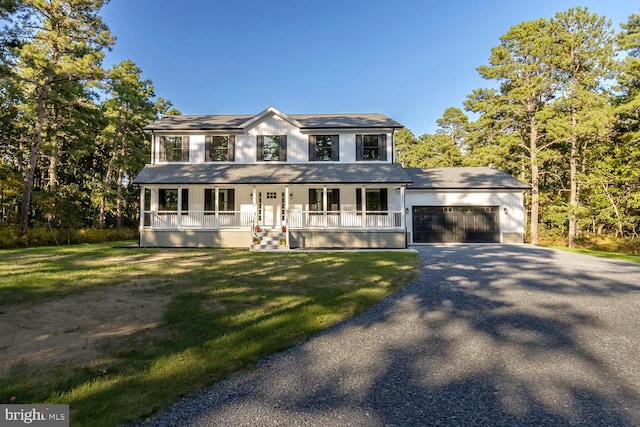 view of front of house featuring a porch, a garage, and a front yard