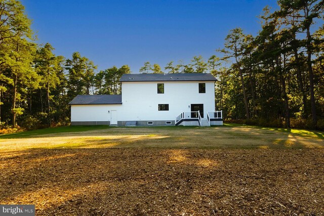 back of property with a lawn and a deck