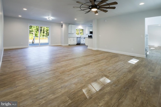 unfurnished living room featuring ceiling fan, light hardwood / wood-style flooring, and sink