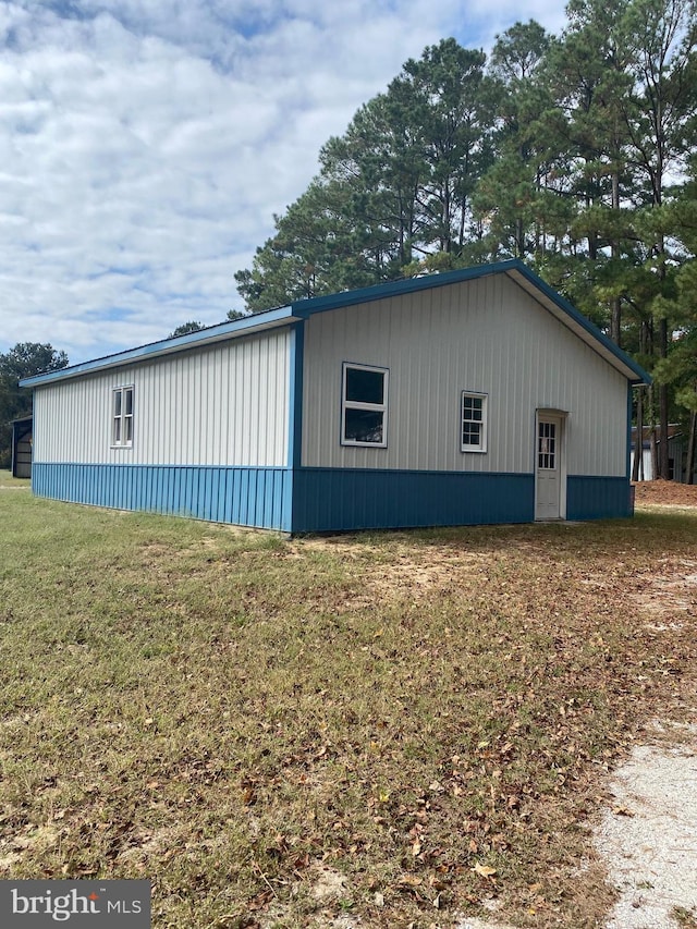 view of side of home with a yard