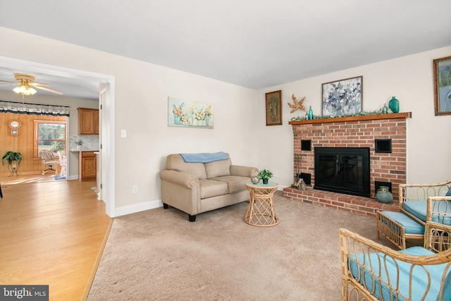 living room with a fireplace, light hardwood / wood-style floors, and ceiling fan