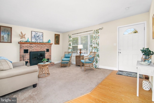 living room with wood-type flooring and a brick fireplace