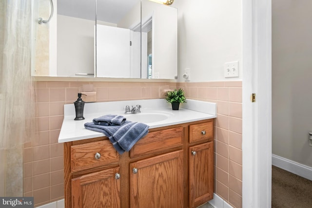 bathroom featuring vanity and tile walls