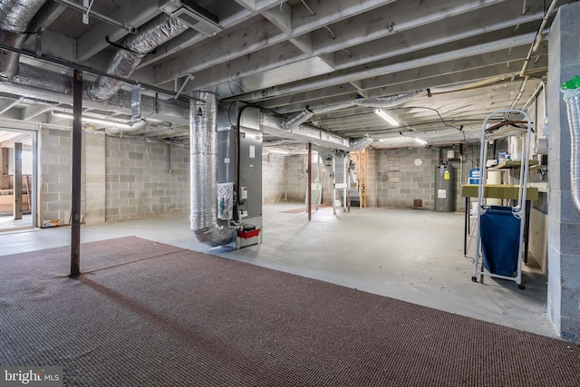 basement featuring electric water heater and heating unit