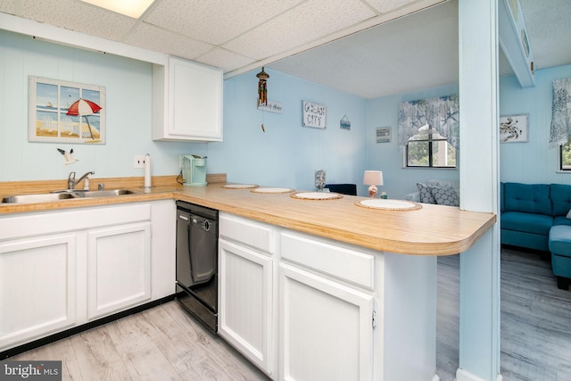 kitchen featuring light wood-type flooring, dishwasher, sink, white cabinets, and kitchen peninsula