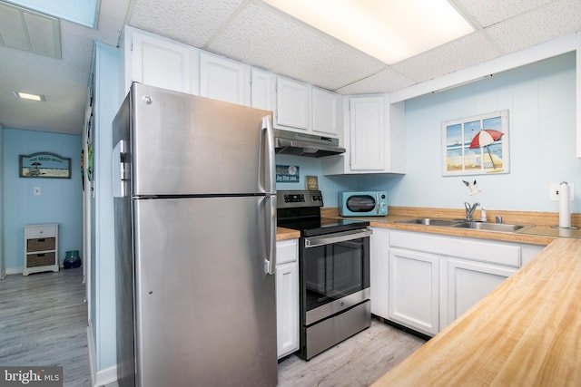 kitchen featuring appliances with stainless steel finishes, light wood-type flooring, sink, and white cabinets