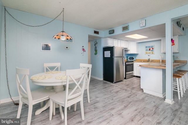 dining room with sink and light hardwood / wood-style floors