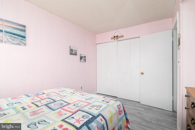 bedroom with light hardwood / wood-style flooring and a closet