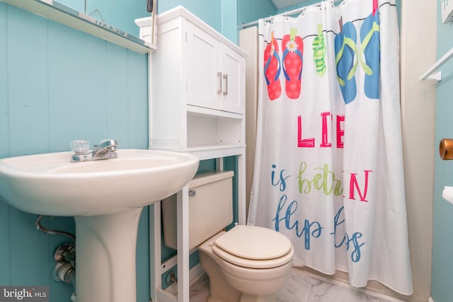 bathroom with sink, curtained shower, and toilet