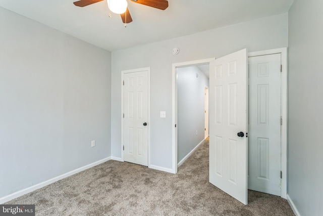 unfurnished bedroom featuring light colored carpet and ceiling fan