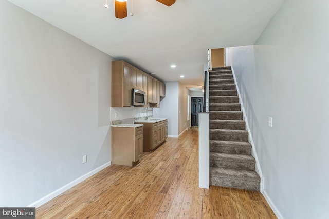 kitchen featuring sink, light wood-type flooring, and ceiling fan