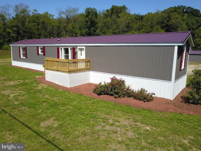 manufactured / mobile home featuring a front lawn and a deck