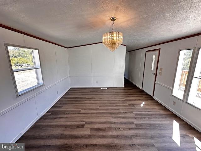 entrance foyer featuring dark hardwood / wood-style floors, an inviting chandelier, crown molding, and a textured ceiling