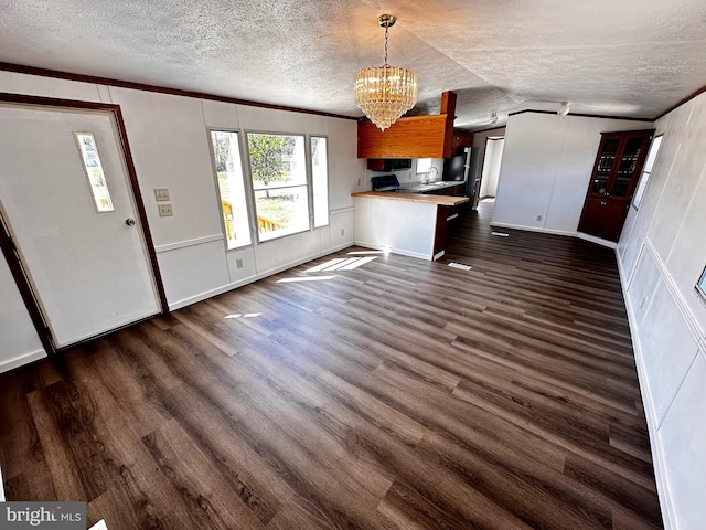 interior space featuring ornamental molding, a textured ceiling, a chandelier, and dark hardwood / wood-style floors