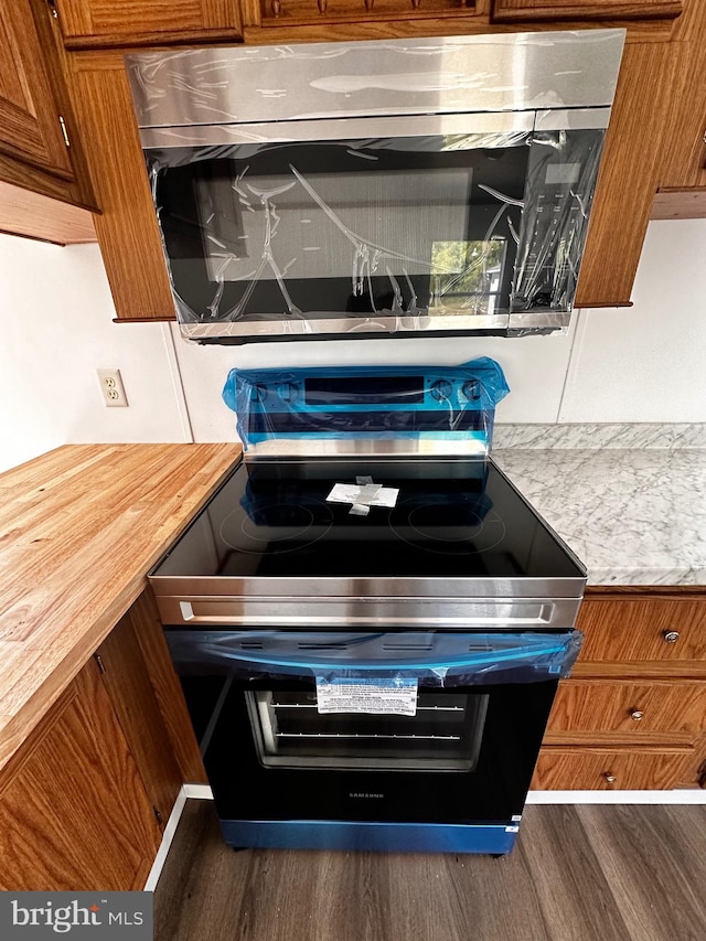 room details featuring range with electric stovetop and dark hardwood / wood-style floors