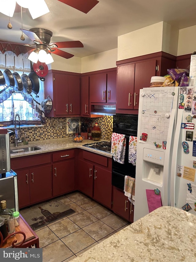 kitchen featuring stainless steel gas stovetop, oven, sink, ceiling fan, and white fridge with ice dispenser