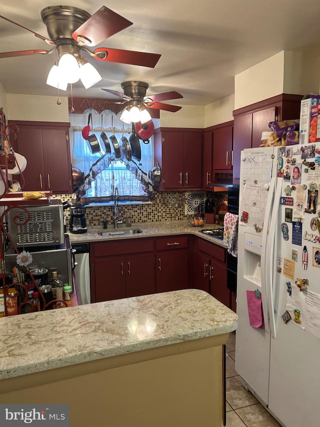 kitchen with light tile patterned floors, appliances with stainless steel finishes, sink, ceiling fan, and tasteful backsplash