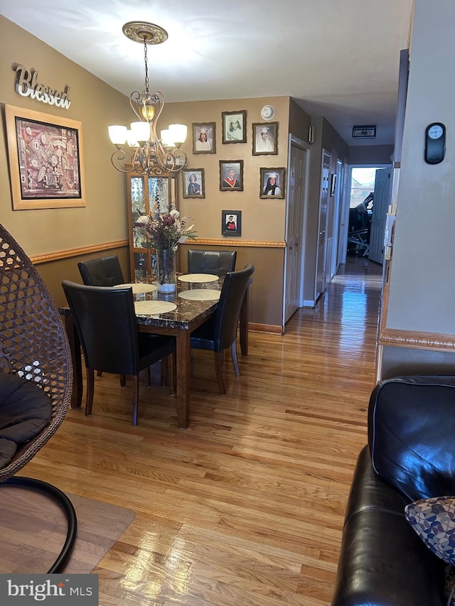 dining space featuring a notable chandelier and hardwood / wood-style floors