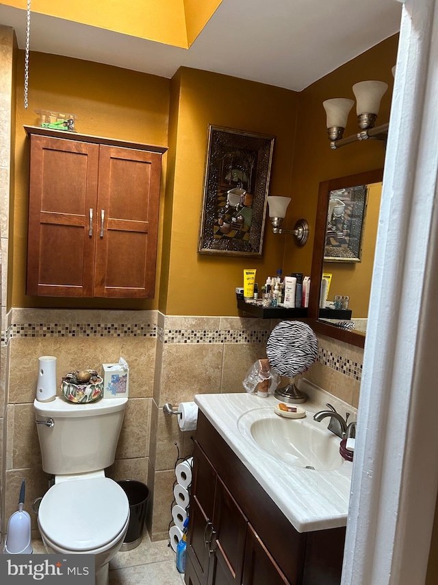 bathroom with tile patterned flooring, vanity, toilet, and tile walls