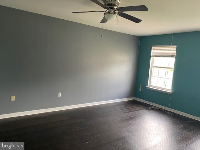 spare room featuring ceiling fan and dark hardwood / wood-style floors