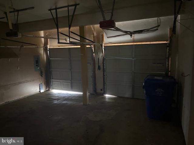 garage with a garage door opener and electric panel