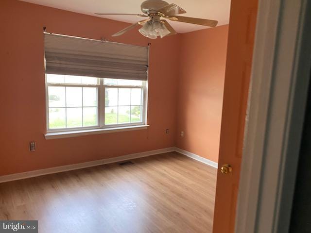 spare room with ceiling fan and light wood-type flooring